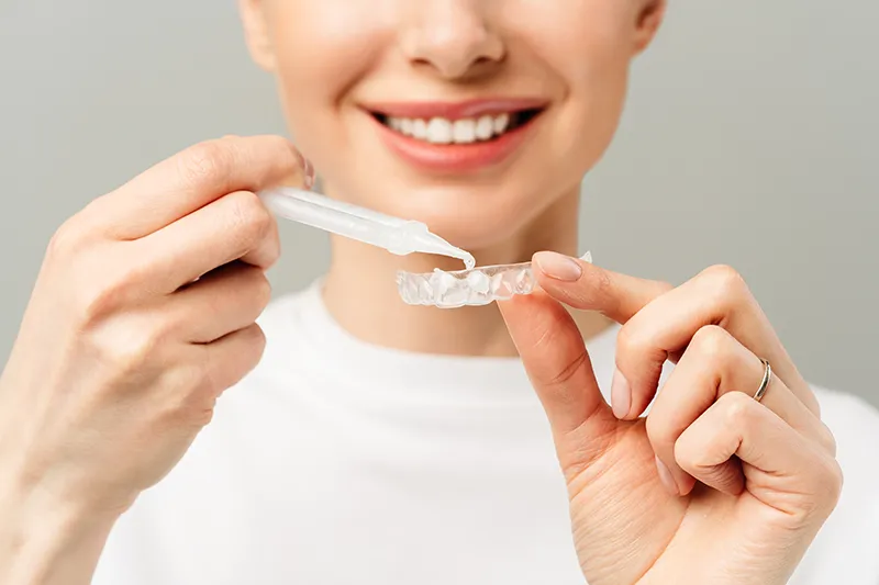 Woman holding custom teeth whitening trays