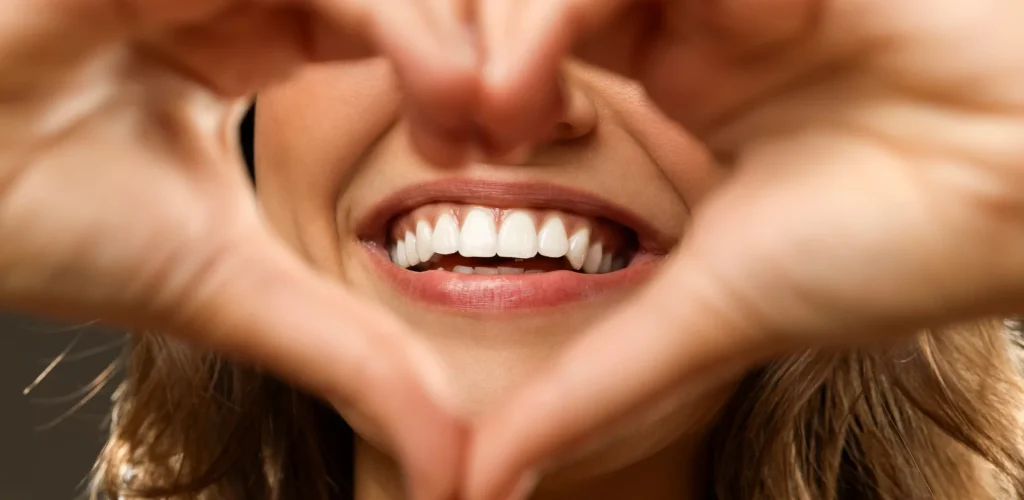 Woman framing her white smile with her hands